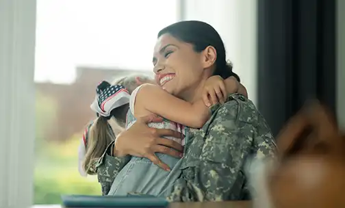 Military woman laughing while hugging her daughter