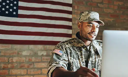 military service member on their computer