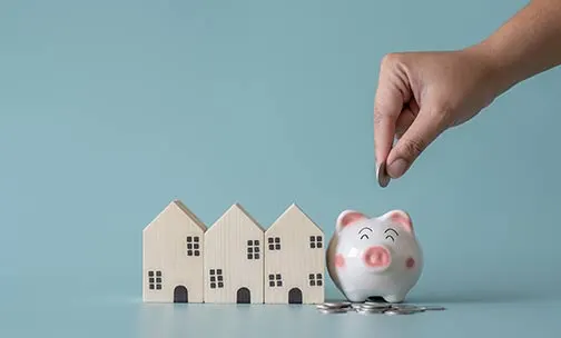 Piggy bank and small wooden house at back concept of savings. Save money to buy , loan , rent the house.