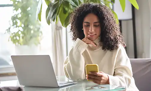 Young happy pretty woman sitting at home holding smartphone using cellphone.  217 of 625 assets