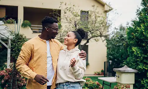 Young beautiful couple applying for mortgage. Sitting smiling happy meeting with real state agent considering mortgage loan at