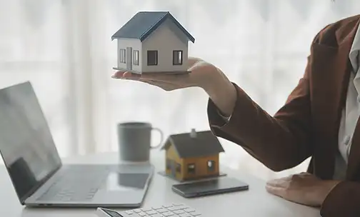 Person holding the wooden home miniature